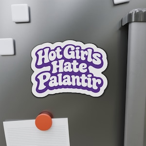 Può includere: Un adesivo fustellato con sfondo bianco e un bordo spesso di colore viola. L'adesivo presenta il testo "Hot Girls Hate Palantir" scritto in un carattere viola audace, arrotondato e in stile retrò. Il design ha una forma ondulata e irregolare.