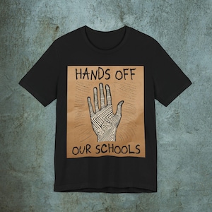 Camiseta unissex com placa de protesto, "Tirem as mãos das nossas escolas", visual realista de papelão, placa desenhada à mão, manifestação 50501, anti-Trump, camiseta gráfica, Resista