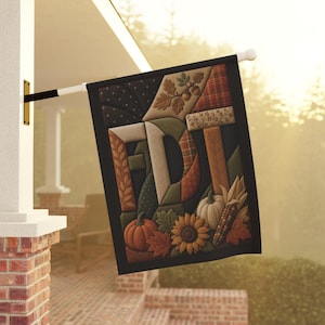 Peut inclure: Un drapeau de jardin rectangulaire affichant les lettres F, D et T dans un style patchwork matelassé. Le motif intègre des éléments automnaux tels que des citrouilles, un tournesol, un épi de maïs, des feuilles de chêne et des glands.