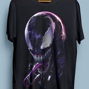 Puede incluir: Camiseta negra con un estampado gr&aacute;fico de Venom, un superh&eacute;roe ficticio, en un esquema de colores morado y negro. El gr&aacute;fico muestra la cara de Venom con una boca grande y dientes afilados.