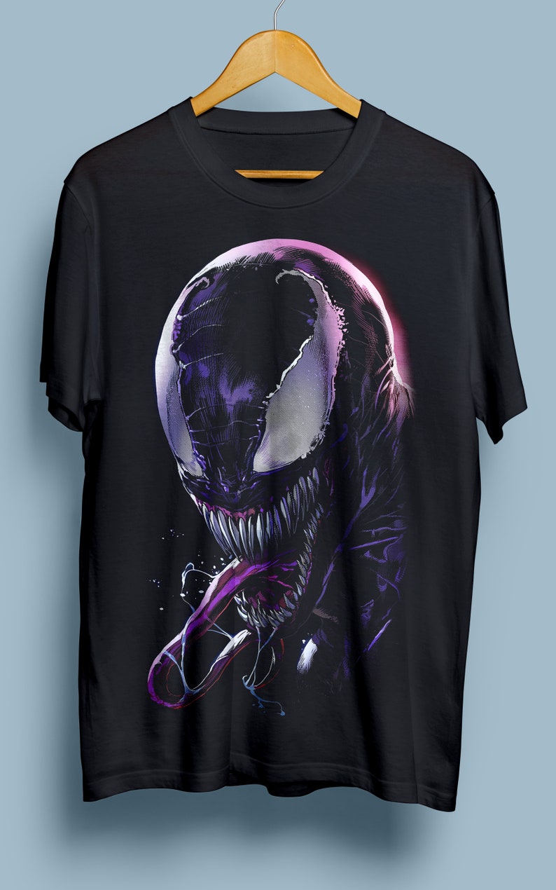 Puede incluir: Camiseta negra con un estampado gr&aacute;fico de Venom, un superh&eacute;roe ficticio, en un esquema de colores morado y negro. El gr&aacute;fico muestra la cara de Venom con una boca grande y dientes afilados.
