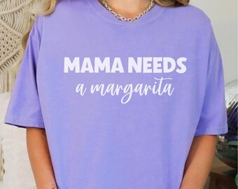 May include: A lavender t-shirt with the text "MAMA NEEDS a margarita" in white.