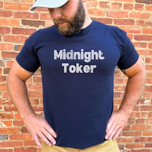 May include: A navy blue t-shirt with the text "Midnight Toker" printed in white on the front.