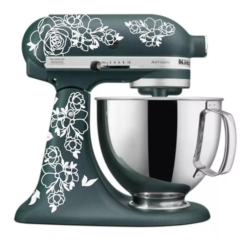 May include: A teal stand mixer with a silver bowl and white floral decals. The mixer has a control panel with the word "Artisan" and numbers 2, 4, 6, 8, and 10.