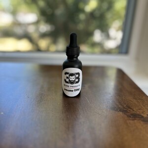 May include: A black glass bottle with a dropper top and a white label that says "Beard Products 33 Volume You".