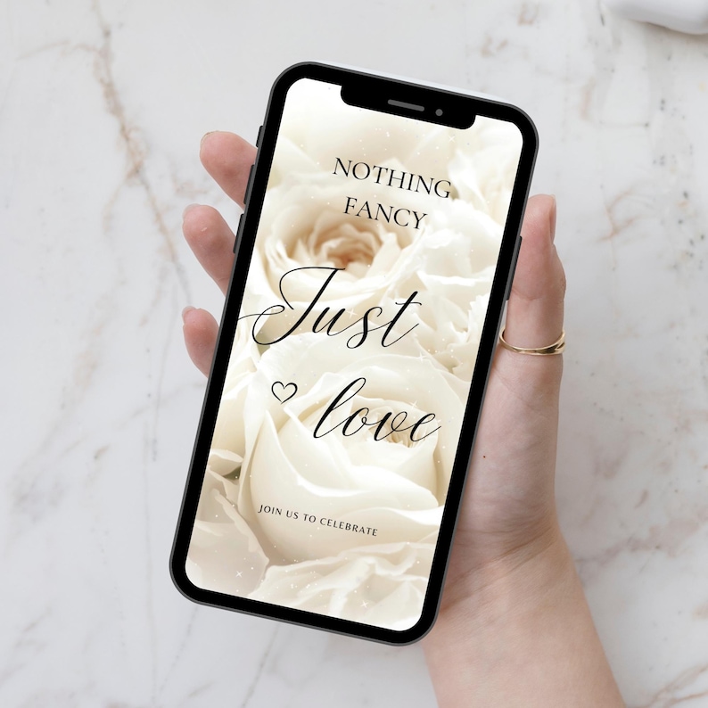 May include: A smartphone displaying a wedding invitation with a white rose background and the text "Nothing Fancy Just Love" and "Join Us To Celebrate".