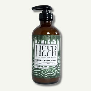 Könnte beinhalten: Eine braune Glasflasche mit einem Pumpspender, gefüllt mit einer klaren Flüssigkeit. Das Etikett ist grün und weiß mit dem Text "HEFR HOLISTIC ELIXIRS FOR RADIANCE SIMPLE SUDS SOAP RADIANCE REDEFINED LAVENDER + TEA TREE 8 oz."