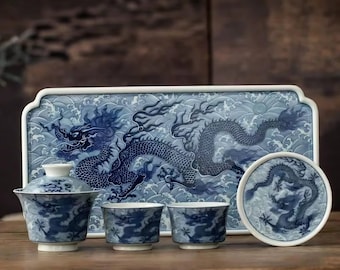 May include: A blue and white porcelain tea set featuring a dragon design. The set includes a teapot with a lid, two teacups, a coaster, and a rectangular tray. The dragon is depicted in a detailed, stylized manner against a wave pattern.