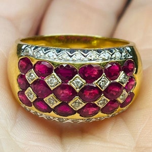 May include: A gold ring with a band of rubies and diamonds. The rubies are set in a checkerboard pattern and the diamonds are set in a row around the edge of the band.