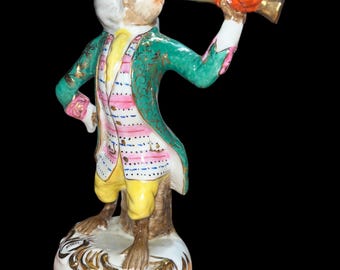 Vintage hand-painted porcelain monkey musician figurine holding a horn/trumpet, dressed in aristocratic 18th-century attire (Singerie style)