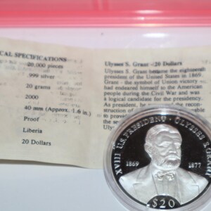 May include: A silver proof coin commemorating Ulysses S. Grant, the 18th president of the United States. The coin features a portrait of Grant and the text "XVIII US. PRESIDENT OLYSSES S. GRANT 1869 1877" around the edge. The coin is 40 mm in diameter and has a face value of 20 dollars.