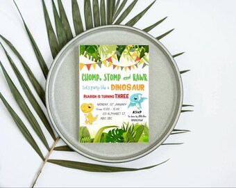 May include: A colorful dinosaur birthday party invitation with green, red, yellow, and blue accents. The invitation features the text "CHOMP, STOMP & RAWR Let's party like a DINOSAUR Ruaridh is turning THREE MONDAY, 1ST JANUARY from 13:00 - 15:00 123 Alphabet St, ABIZ 3BC RSVP 67831234567".