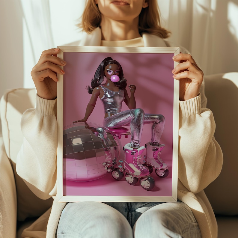 May include: A framed print of a doll wearing a silver outfit and roller skates, sitting on a pink disco ball. The doll is blowing a pink bubble.