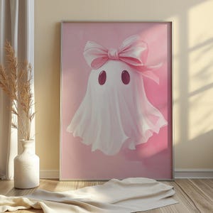 May include: A pink and white ghost with a pink bow on its head. The ghost is on a pink background.