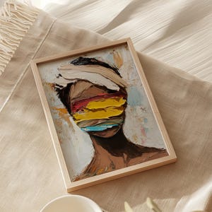 May include: A framed abstract painting of a person's face with colorful brushstrokes covering the eyes. The painting is done in a textured style with a light background.