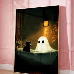 Op de afbeelding: Een ingelijste kunstdruk toont een spook in een badkuip met een zwarte kat. Het spook heeft grote, ronde ogen. De badkamer is zwak verlicht met een warme gloed van een hanglamp. Het kunstwerk is ingelijst in een goudkleurige lijst.