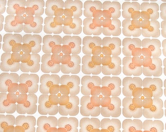 Puede incluir: Un patrón repetitivo de formas florales marrones y naranjas sobre un fondo blanco. El patrón está formado por tréboles de cuatro hojas con un círculo en el centro.