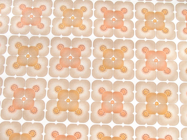 May include: A repeating pattern of brown and orange floral shapes on a white background. The pattern is made up of four-leaf clover shapes with a circle in the center.