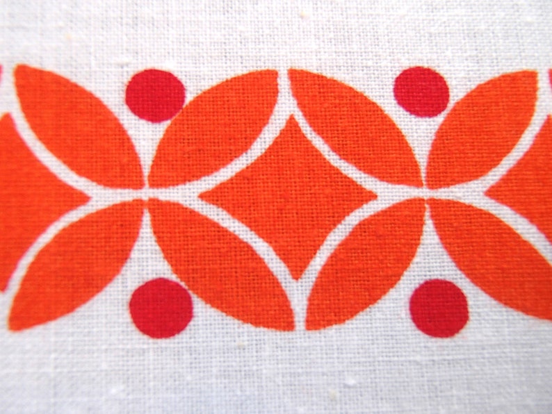 May include: Orange and red geometric pattern on a white fabric background. The pattern features a repeating design of overlapping circles and diamonds.