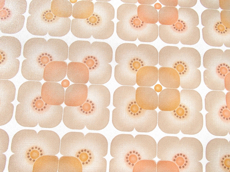 May include: A repeating pattern of brown and orange flower shapes on a white background. The flowers have a textured look and are arranged in a grid pattern.
