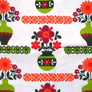 May include: A white fabric with a repeating pattern of green, orange and red flowers in vases. The flowers are stylised and have a retro look. The vases are green with brown and white accents.