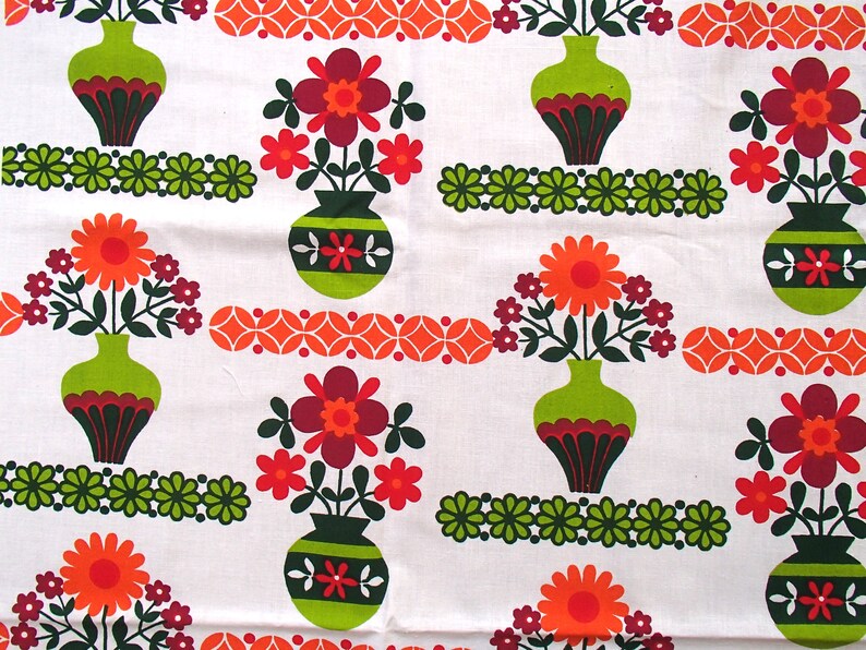 May include: A white fabric with a repeating pattern of green, orange and red flowers in green vases. The flowers have a retro 1970s style.