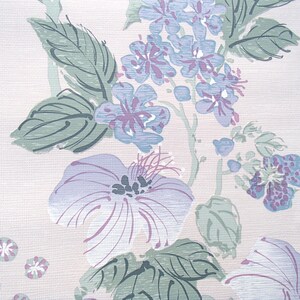 May include: A vintage floral wallpaper pattern with a light pink background and a design of purple and blue flowers with green leaves.