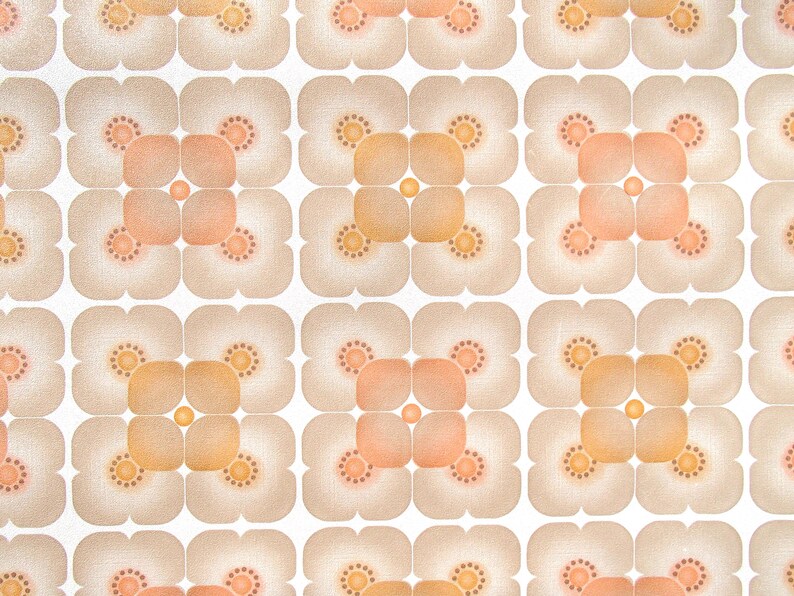 May include: A repeating pattern of beige and orange flower-like shapes on a white background. The pattern is symmetrical and has a retro feel.