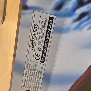May include: A product packaging section featuring the text 1 (800) 524-TOYS, CONFORMS TO THE SAFETY REQUIREMENTS OF ASTM F963, and We are dedicated to quality products. The box includes a CE mark, a small icon of a child, and contact information.