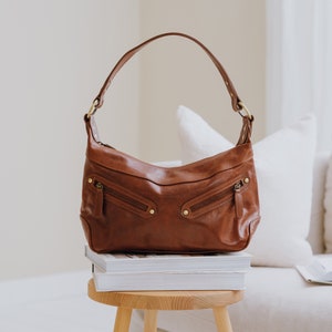 tan leather shoulder bag with crossbody strap and two front zipped pockets