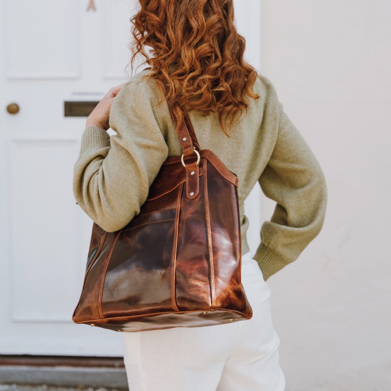 model wearing large brown leather tote over her shoulder