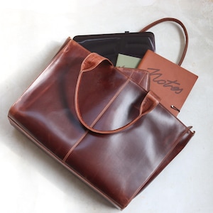 Verity brown leather oversized tote bag flat lay with laptop and notebook showing large capacity