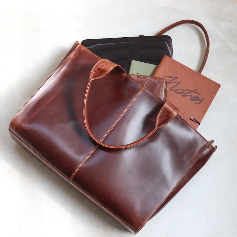 Verity brown leather oversized tote bag flat lay with laptop and notebook showing large capacity