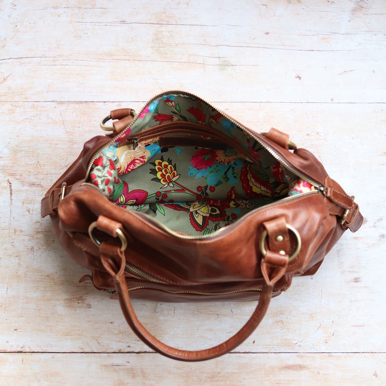 Hampton brown leather handbag open from above showing vibrant floral fabric lining and interior zip pocket