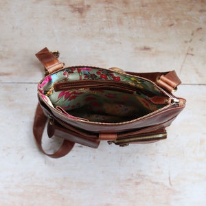 brown leather crossbody bag with floral fabric lining and zip closure