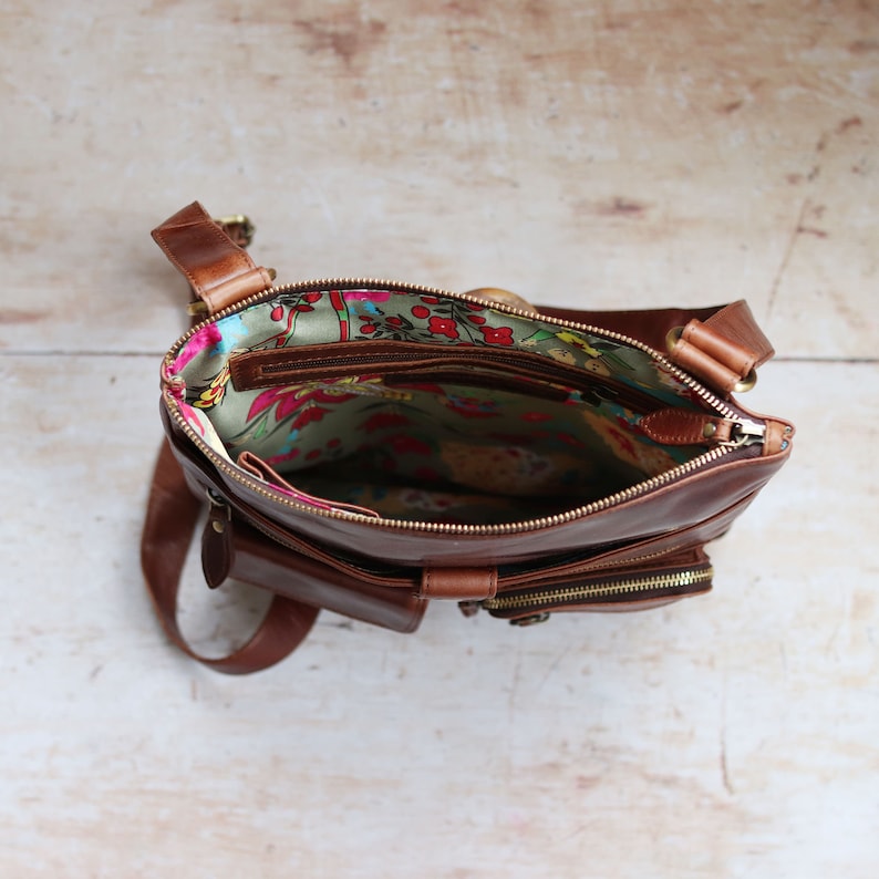 brown leather crossbody bag with floral fabric lining and zip closure