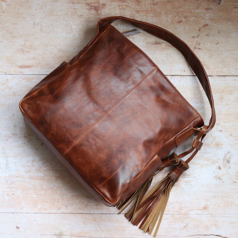 tan soft leather handbag with large double tassel and handle