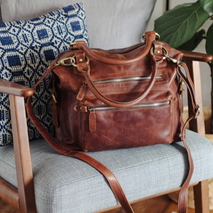 brown leather shoulder bag with two zipped front pockets and long detachable crossbody strap
