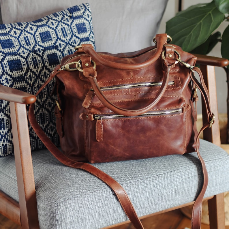 brown leather shoulder bag with two zipped front pockets and long detachable crossbody strap