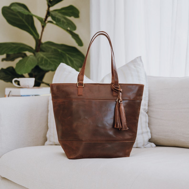 large brown leather tote bag with a tassel