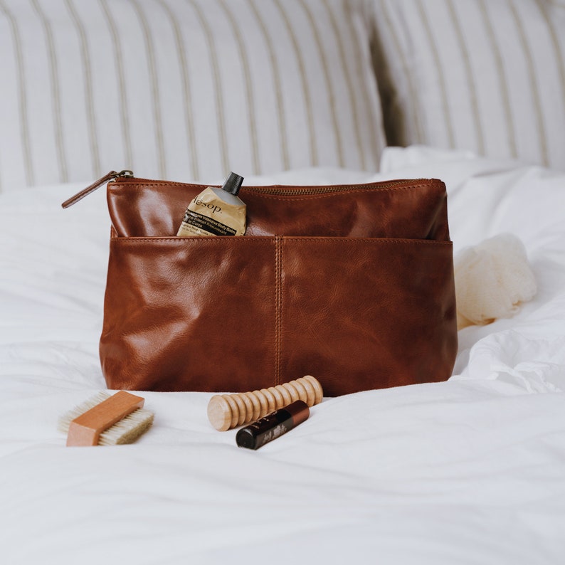 tan leather wash bag with two front pockets and zip closure