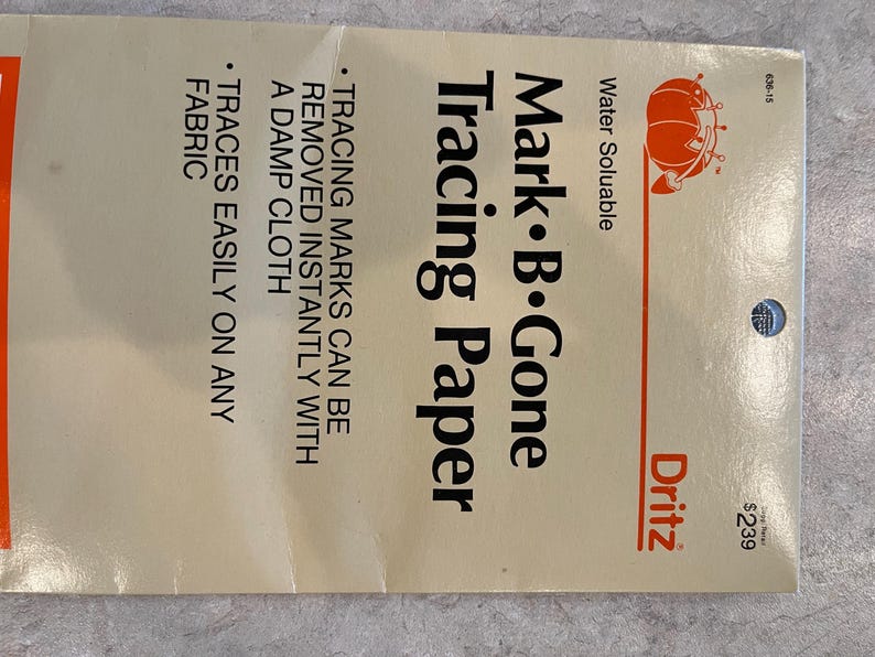 May include: A package of Mark B. Gone Tracing Paper by Dritz. The package is cream-colored with red and black text. The text includes "Water Soluble" and "Tracing Paper". The paper traces easily on any fabric and marks are removed with a damp cloth.