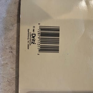 May include: A close-up of a beige product package with a barcode and the text "&copy; 1987 Dritz CORPORATION Spartanburg, SC 29304". The barcode is black and the text is black.
