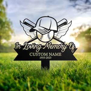 May include: Black metal memorial garden stake with a baseball, bat, and wings design. The stake has a banner that reads "In Loving Memory Of" with a space for a custom name and dates.  1955-2023