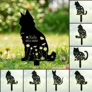 Könnte beinhalten: Ein Set mit 10 schwarzen Metall-Gartenstecken in Form von Katzensilhouetten mit Blumendesigns und personalisierten Namen. Jeder Stecker zeigt eine andere Katzenpose und enthält den Namen des Haustieres und die Daten.