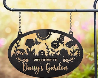 May include: Black metal garden sign with a cut-out design of flowers, butterflies, and a sun. The sign reads "Welcome to Daisy's Garden".