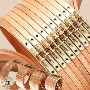 May include: A collection of wooden embroidery hoops with brass fittings. The hoops are fanned out, displaying the wood grain. Smaller hoops are also present, indicating a range of sizes. The brass hardware provides a classic look. Ideal for various craft projects.