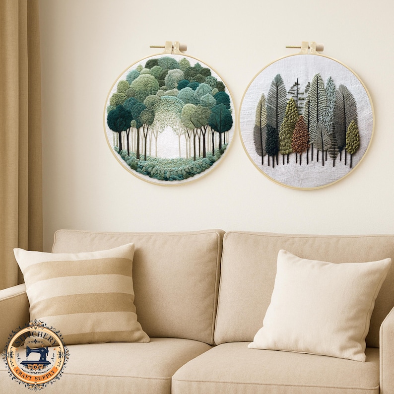May include: Two round embroidery hoops with forest scenes. One features a tunnel of trees in shades of green, the other showcases various tree types in green, brown, and gray. Both are mounted on a cream-colored background.