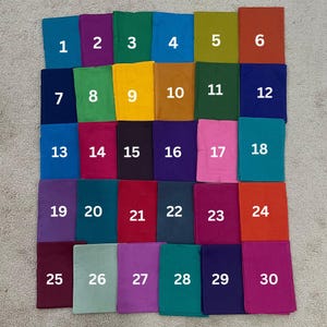 Pode incluir: Trinta amostras de tecido numeradas de 1 a 30. As amostras estão dispostas em cinco filas de seis amostras cada. As amostras são de várias cores, incluindo vermelho, azul, verde, roxo, amarelo, laranja e marrom.