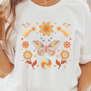 Camiseta unissex com borboleta psicodélica dos anos 70, camisa vintage retrô com flores, blusa colorida com notas musicais, camiseta com estampa vibrante, roupa para festivais, estilo boho